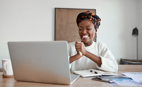 female employee smiling at something on her laptop screen