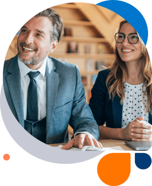 image of a male and female employee sitting at a table and smiling